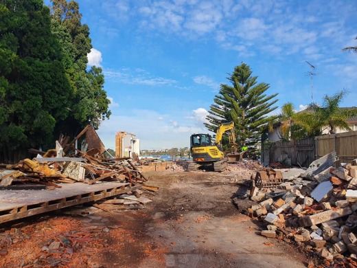 Earthmoving demolition contractors at work on residential property