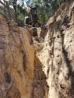 sandstone clay trench digging and pipe installation preparation with excavator