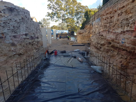 polythene sheets on a residential property excavation with sandstone walls